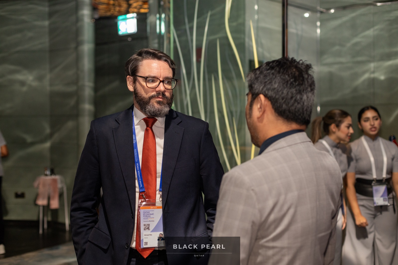 Two members in animated business conversation at a Black Pearl evening